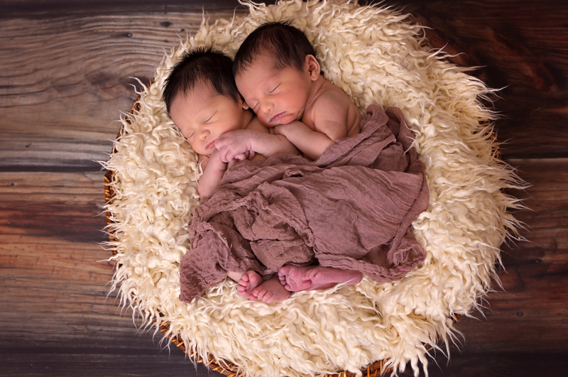 photo of two babies sleeping on a circular rug