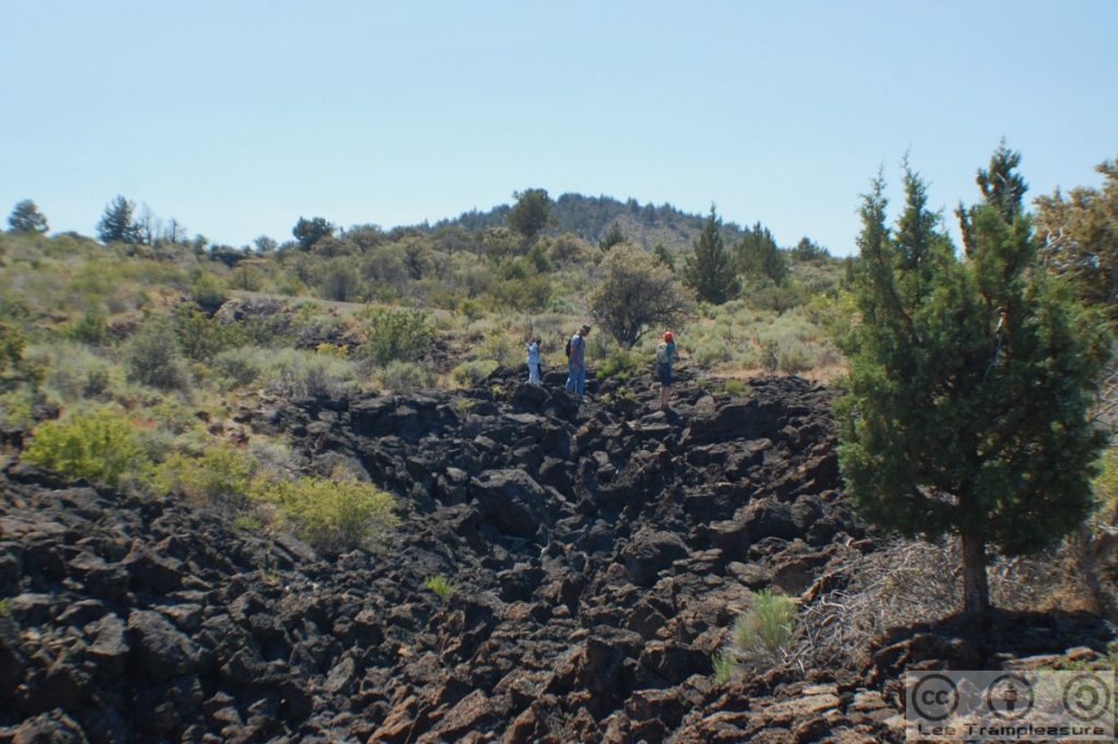 Photo of a group of people hiking along the lava rocks