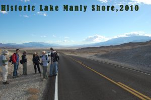 Photo showing group on side of road at top level of historic Lake Manly